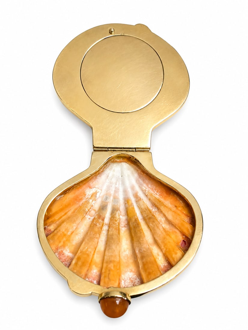 VERDURA (Attrib.). FINE LIONS PAW SHELL COMPACT: VERDURA (Attrib.). FINE LIONS PAW SHELL COMPACT,93.6 grams, stamped 14K.The lovely shell encased in gold mount and carnelian set clasp.The inside with a clasped compartment.L. 8.3 cm.Provenance: From 