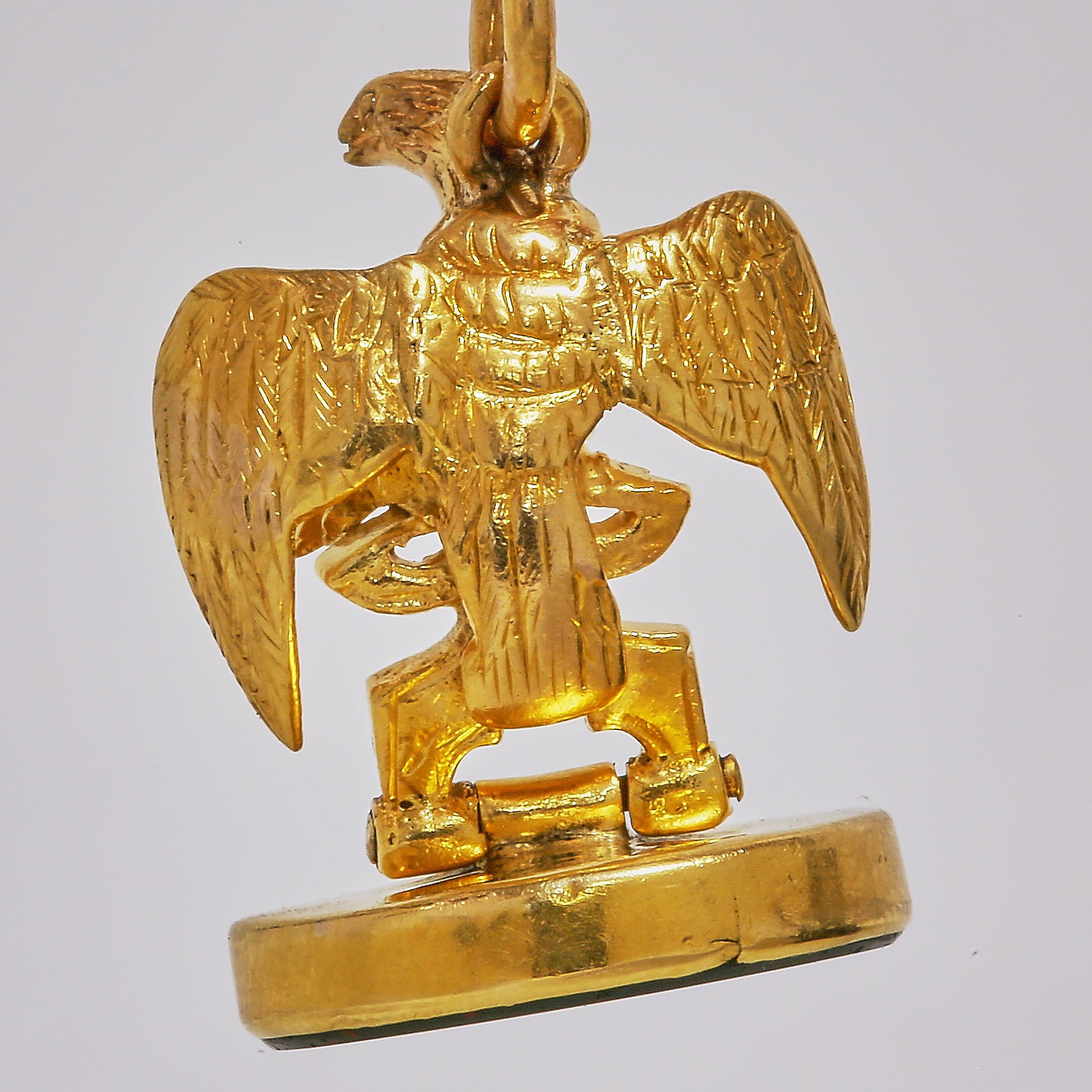 GOLD EAGLE BLOODSTONE FOB SEAL PENDANT: GOLD EAGLE BLOODSTONE FOB SEAL PENDANT,7.9 grams.The 3 dimensional shaped eagle holding a tilting bloodstone in his claws.L. 3.2 cm.