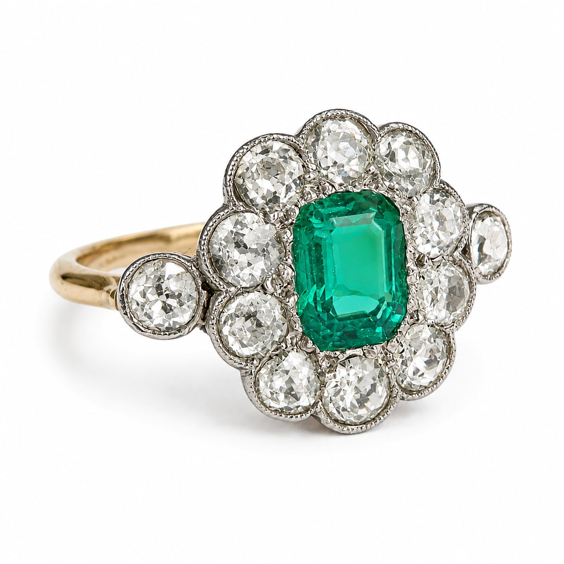 EDWARDIAN EMERALD AND DIAMOND CLUSTER RING: EDWARDIAN EMERALD AND DIAMOND CLUSTER RING,2.8 grams, testing high carat gold and platinum.Rich and vibrant emerald.Diamonds bright and lively, totalling approx. 1.25 ct.Size M.