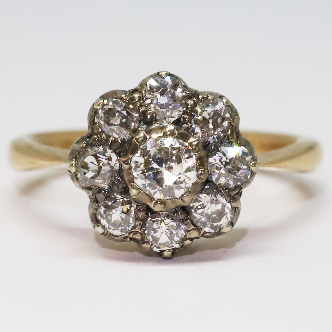 DIAMOND DAISY CLUSTER RING: DIAMOND DAISY CLUSTER RING,4 grams, 18 ct. gold.Bright and lively old cut diamonds, totalling approx. 1.20 ct.Size M.
