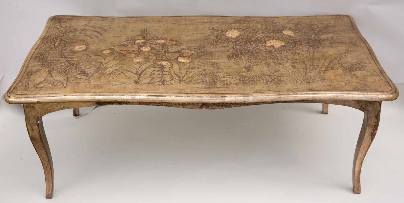 Max Kuehne Silver Leaf Coffee Table: Max Kuehne (1880-1968) Silver leaf and polychrome on gessoed and carved wood with iconic Kuehne Japonesque garden decoration on top and skirt, signed "Max Kuehne" l.r., ca. 1930. Height: 17.5" top: 22