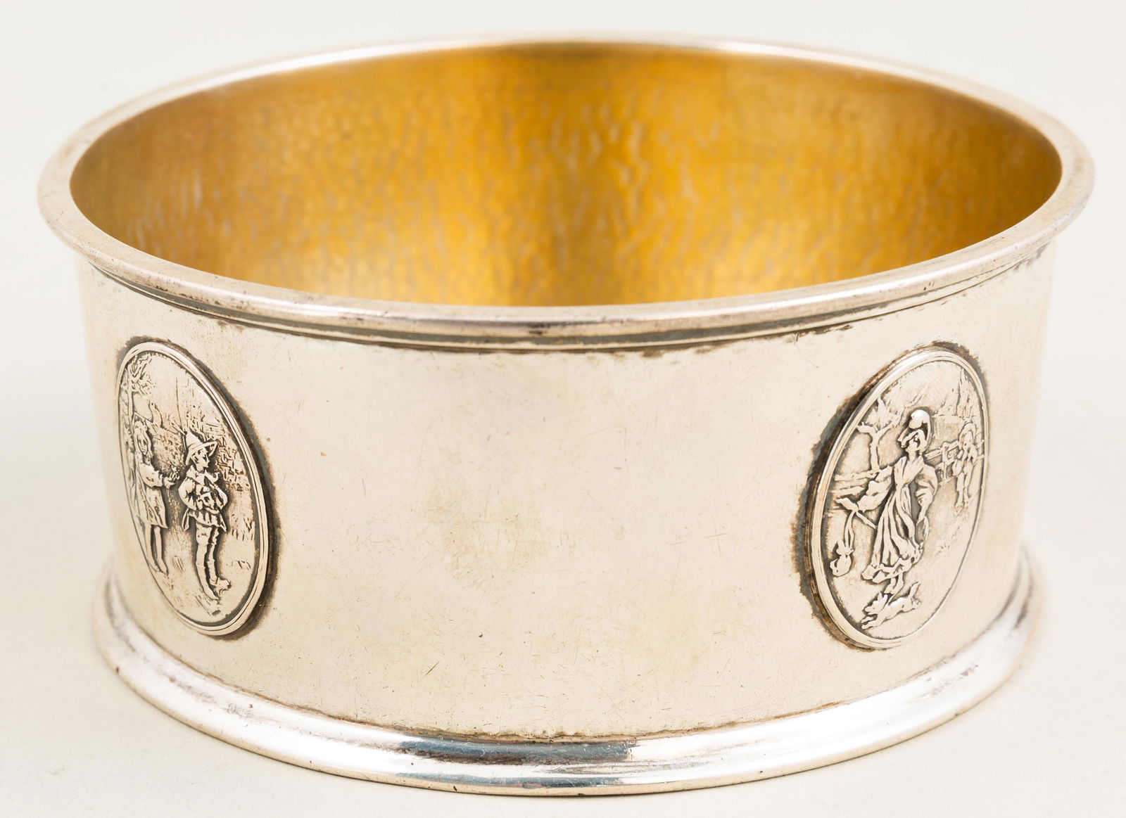 Gorham Sterling Silver Wine Bottle Coaster: Hammered surface with Applied Romantic Scene medallions. Hallmarked as shown. 4 1/2" in diameter. 4.9 troy.