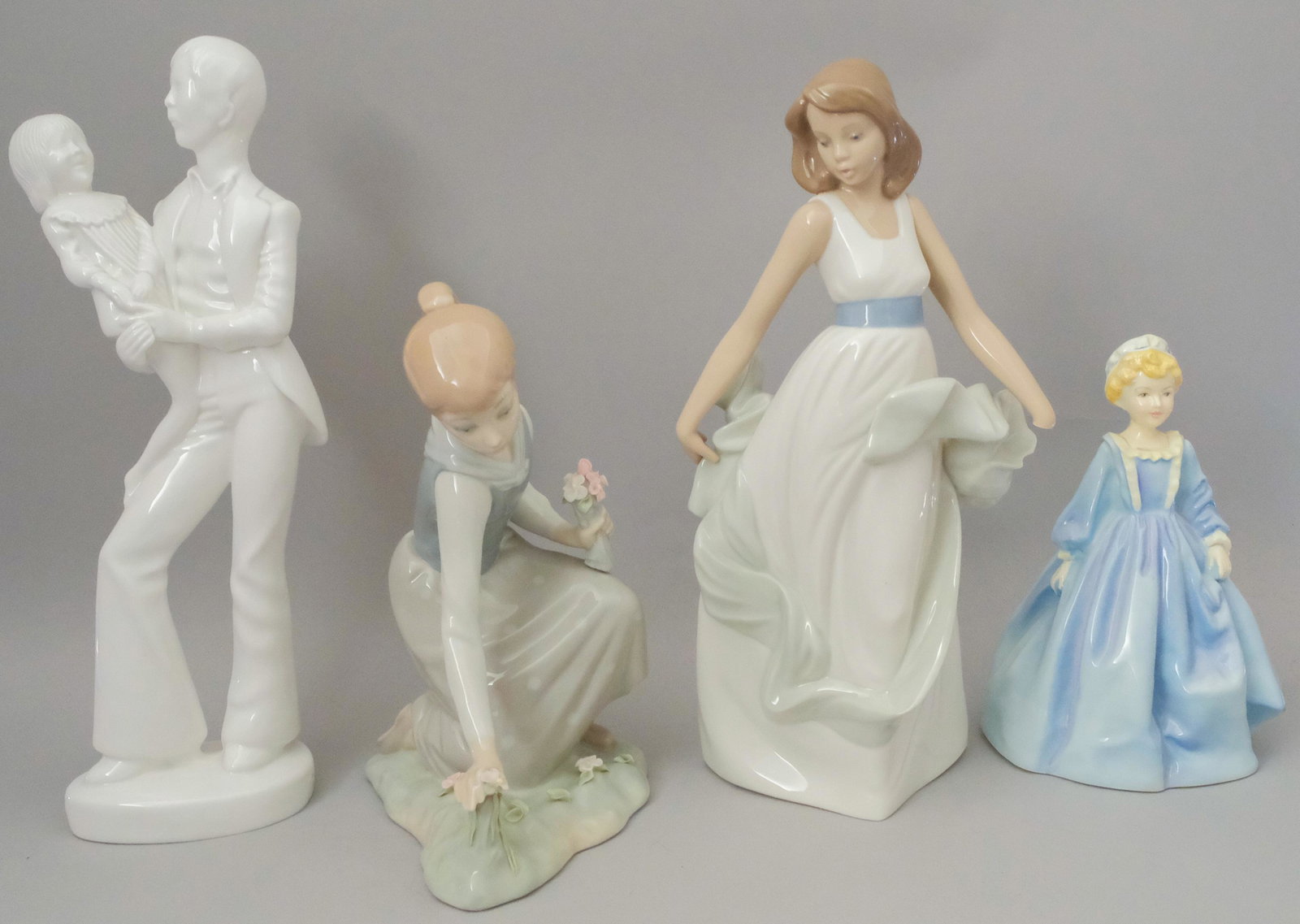 Group of Porcelain Figurines: Including 1 Lladro style figurine with incised marks, 1 Lladro Nao figurine walking on air, 1 Royal Worcester figurine grandmother's dress, 1 Blanc De Sheen father and child figurine by Spode. Tallest