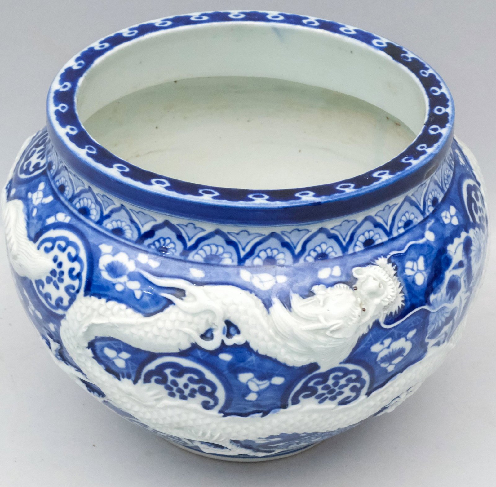 Japanese Blue & White Porcelain Dragon Jardiniere: Meiji Period Arita ware. High relief dragons amongst blue field decoration. 8 x 10".