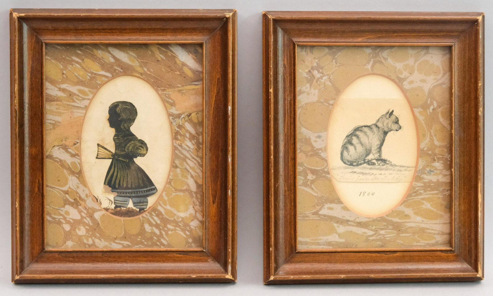 Early American Silhouette and Watercolor of Cat: American, ca. 1820, paint on black paper depicting a child with a fan. Together with a watercolor of a tabby with blue eyes, framed as a pair with matching marbled paper mats, 2 3/4" x 4 1/8" sight, 6