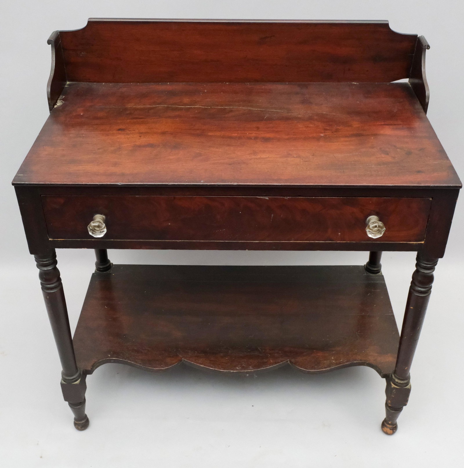 American Empire Mahogany Washstand: With two crystal drawer pulls and scrolled backsplash. 33 1/4" x 18 1/4" x 34 3/4".