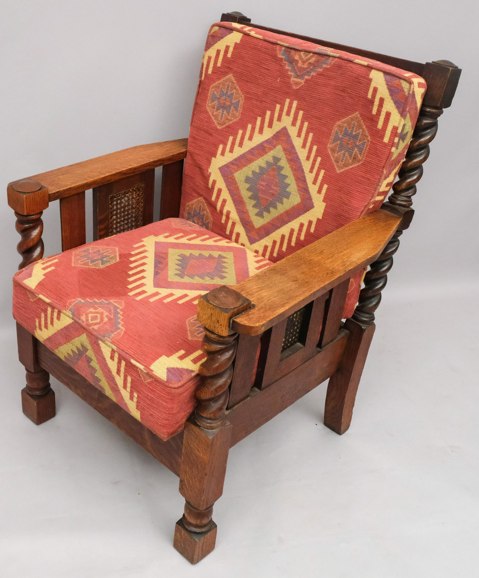 Oak Carved Mission Style Armchair: With tribal upholstered cushions and thick barley twist frame. Original drop seat underneath. 29" x 31" x 36 1/2".
