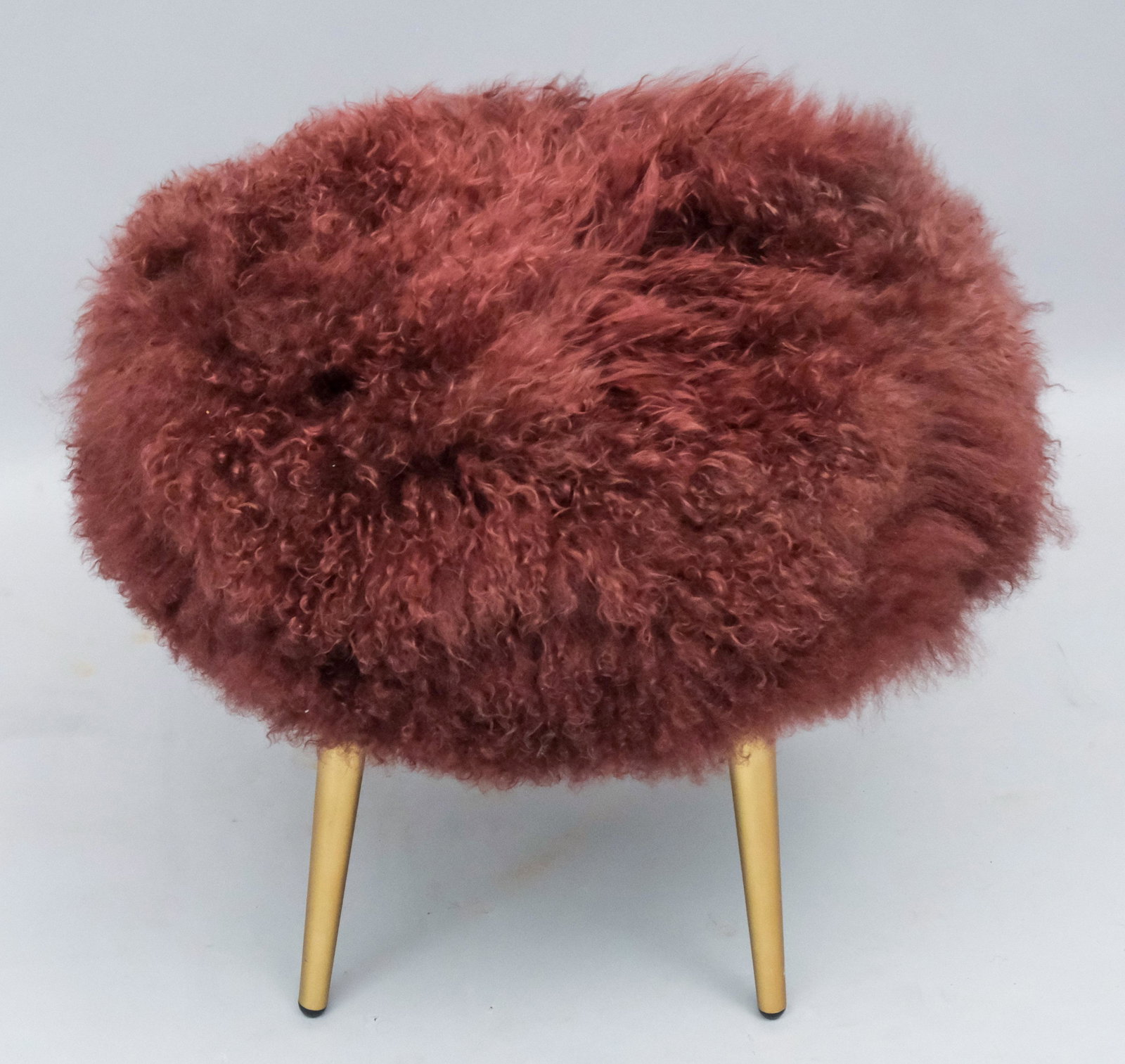Mongolian Lamb Stool by West Elm: Modern stool by West Elm designs with burgundy dyed Mongolian lamb fur upholstery, metal legs with antique brass finish. 17.75" diameter X 17.25" high