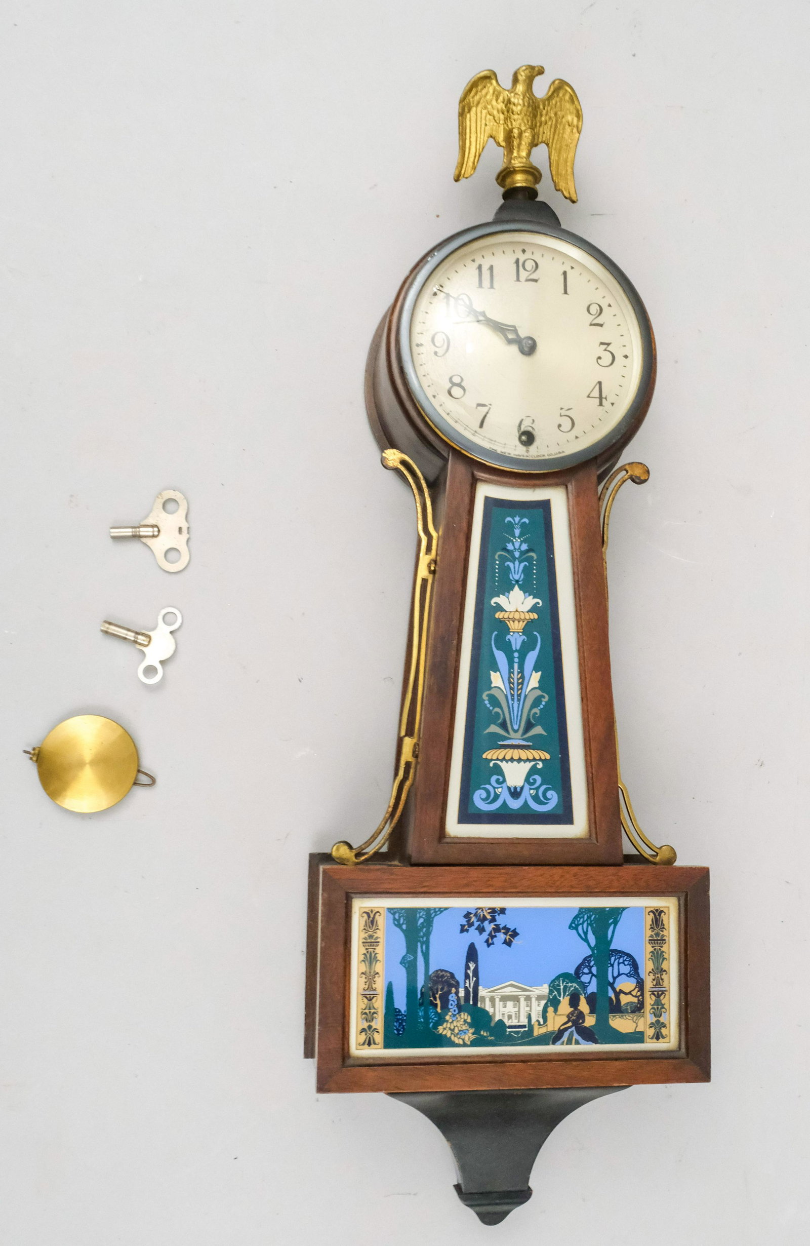 New Haven Clock with Eagle Finial: With verre eglomise panels and eagle finials. 27" long.
