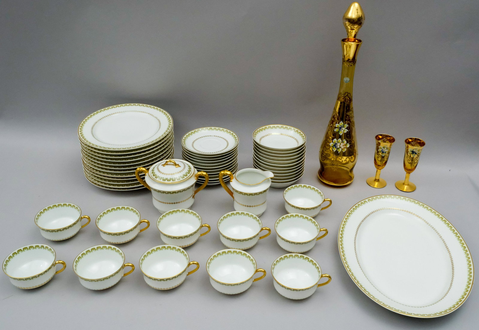 Haviland Limoges Dinner Service.: Service for 12, less one cup, decorated in green and gold. Together with a Murano decanter set with applied enameling.