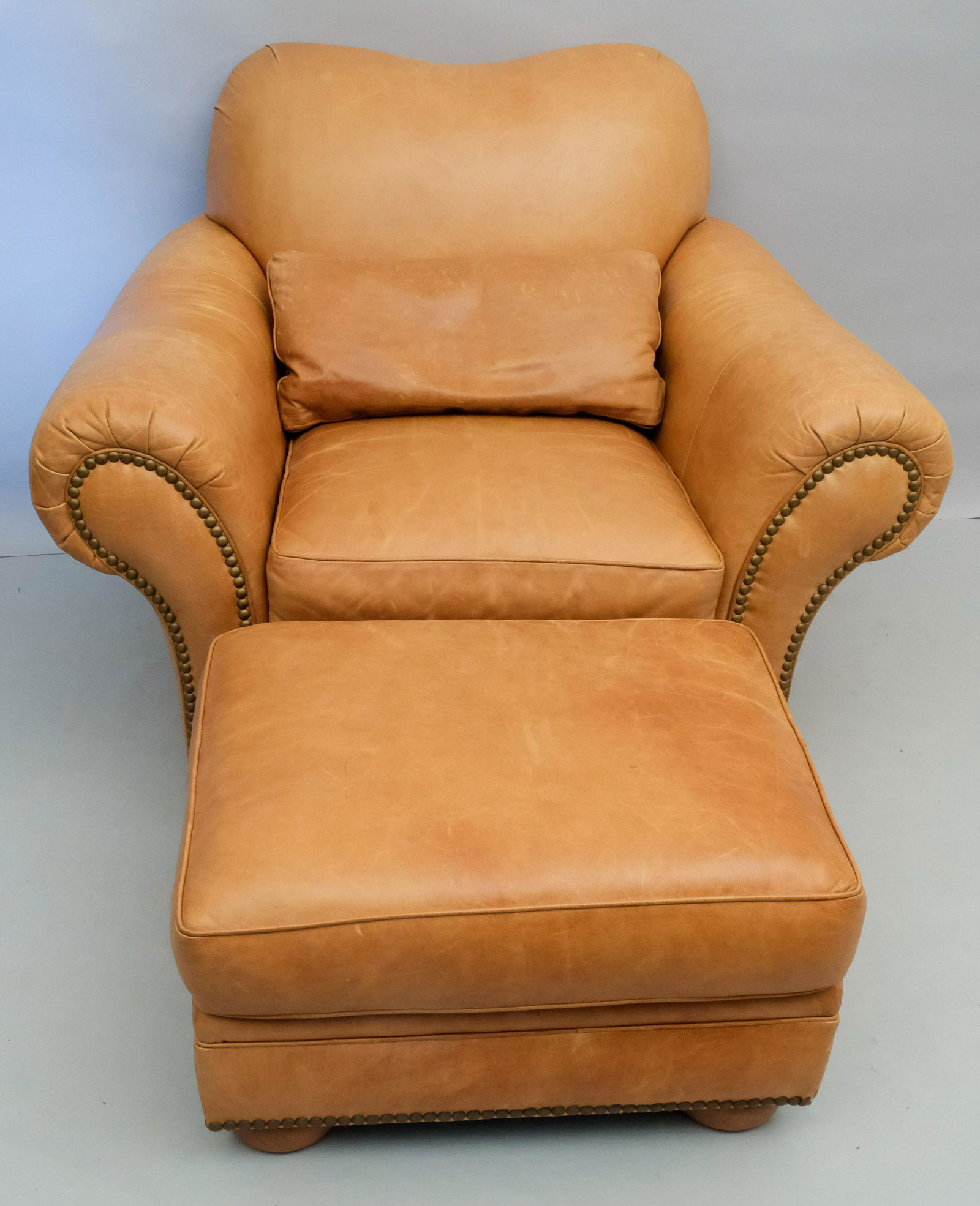 Leather Club Chair and Hassock: Thomasville leather armchair, pillow, and ottoman. Chair measuring 45" x 36" x 38", accompanying hassock measuring 28" x 22" x 16".