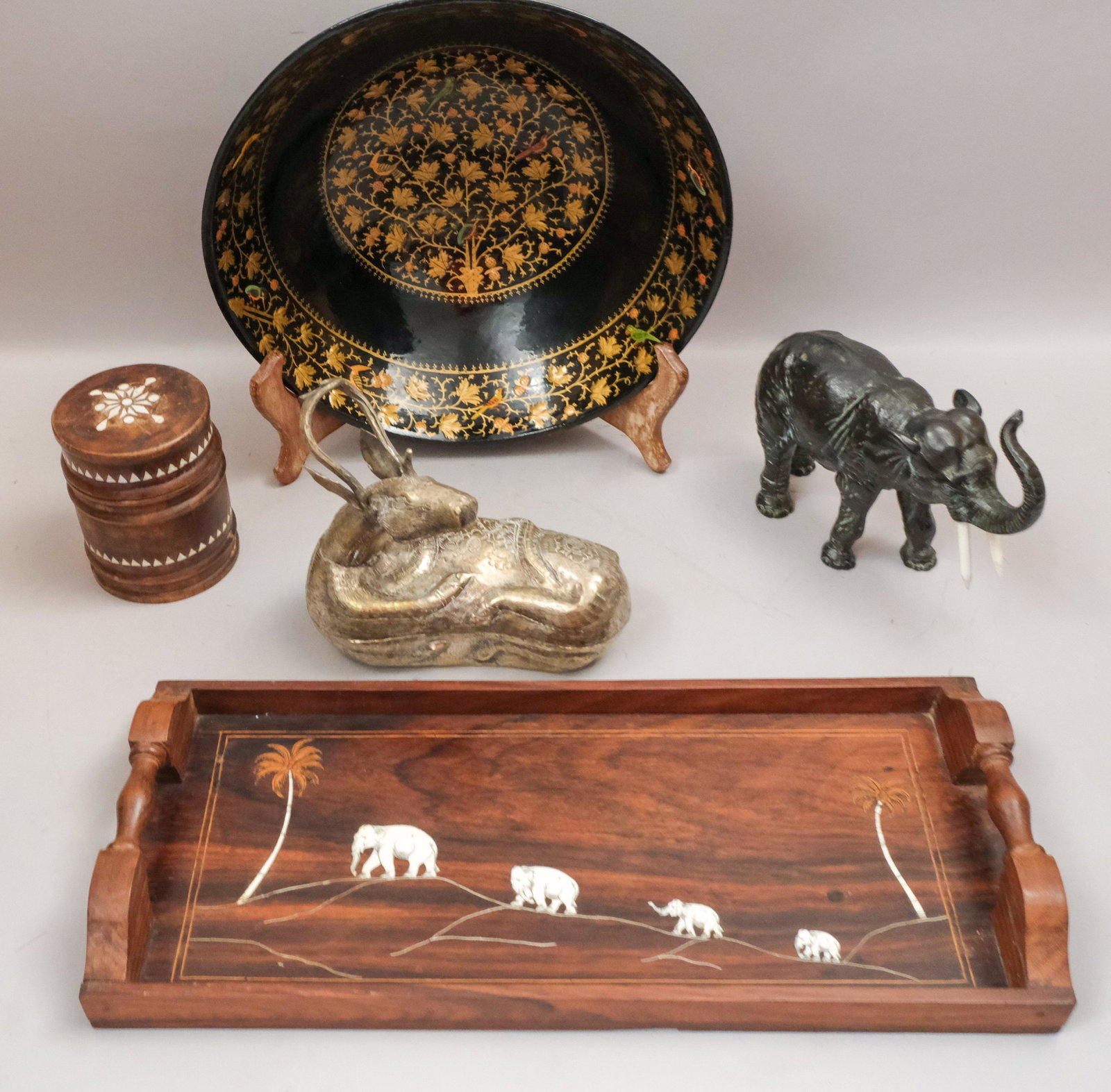 Lot of Asian Decorative Objects and Antiques: Comprising a lacquer bowl with gilt decoration and birds, a rosewood elephant tray, a white metal sculpture of an elephant, a carved Indonesian inlaid box, and a silvered metal antelope box. 3 3/4" - 