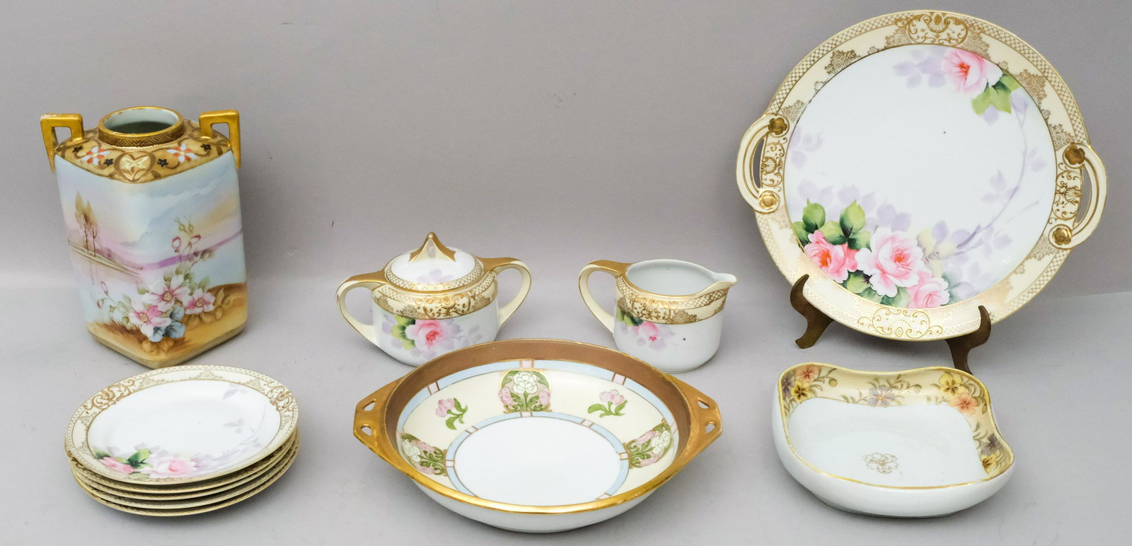 Lot of Antique Noritake Porcelain: Comprising a sugar and creamer, dessert plates, a vase, etc. Plates measure 6 1/2" and the vase 8".