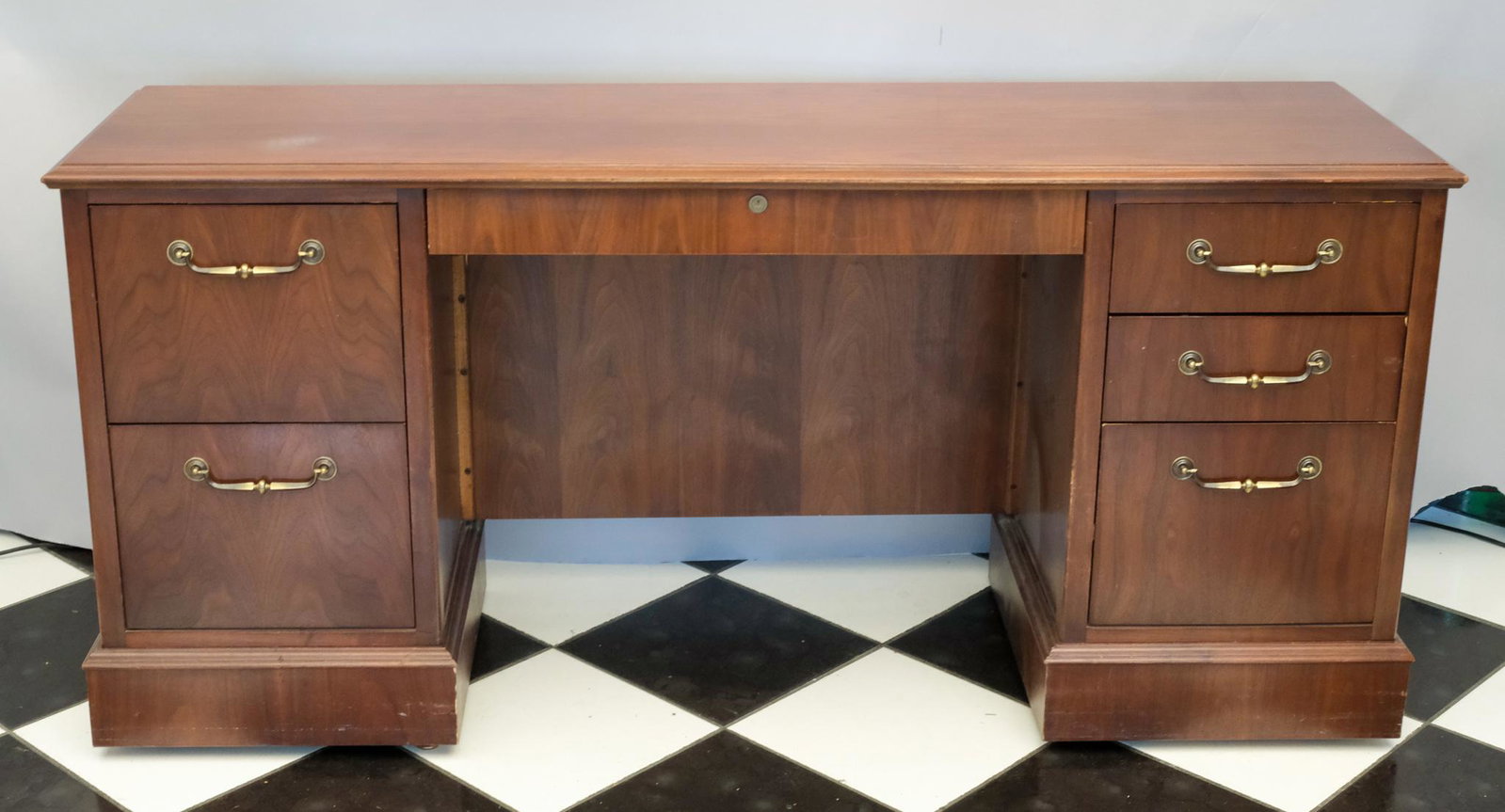 Traditional Executive Office Desk: Three drawers on one side, two on the other, with one central drawer. Oversize brass handles. Measuring: 64 1/2" x 19 1/2" x 30".