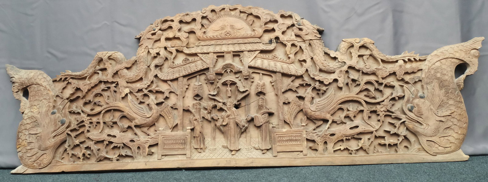 Large Antique Chinese Carved Wood Panel: Most likely an architectural element featuring motifs of sea dragoons, phoenix, and scholars under pagoda. With rising sun motif, scrolling clouds, and highly dimensional elements. Measuring 78" x 26"