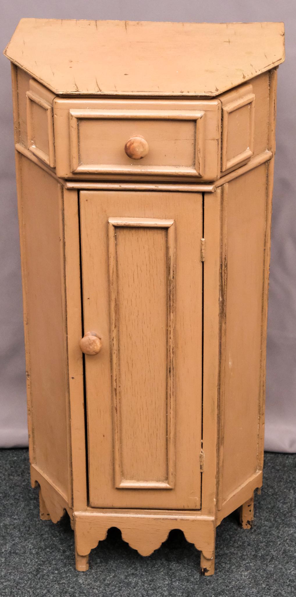 Folk Art Diminutive Stand: Hexagonal primitive cover with applied elements at skirt and top. Single door cupboard under drawer with round wooden knobs in restrained mauve. measures: 25" x 9 1/4" x 12 1/4".