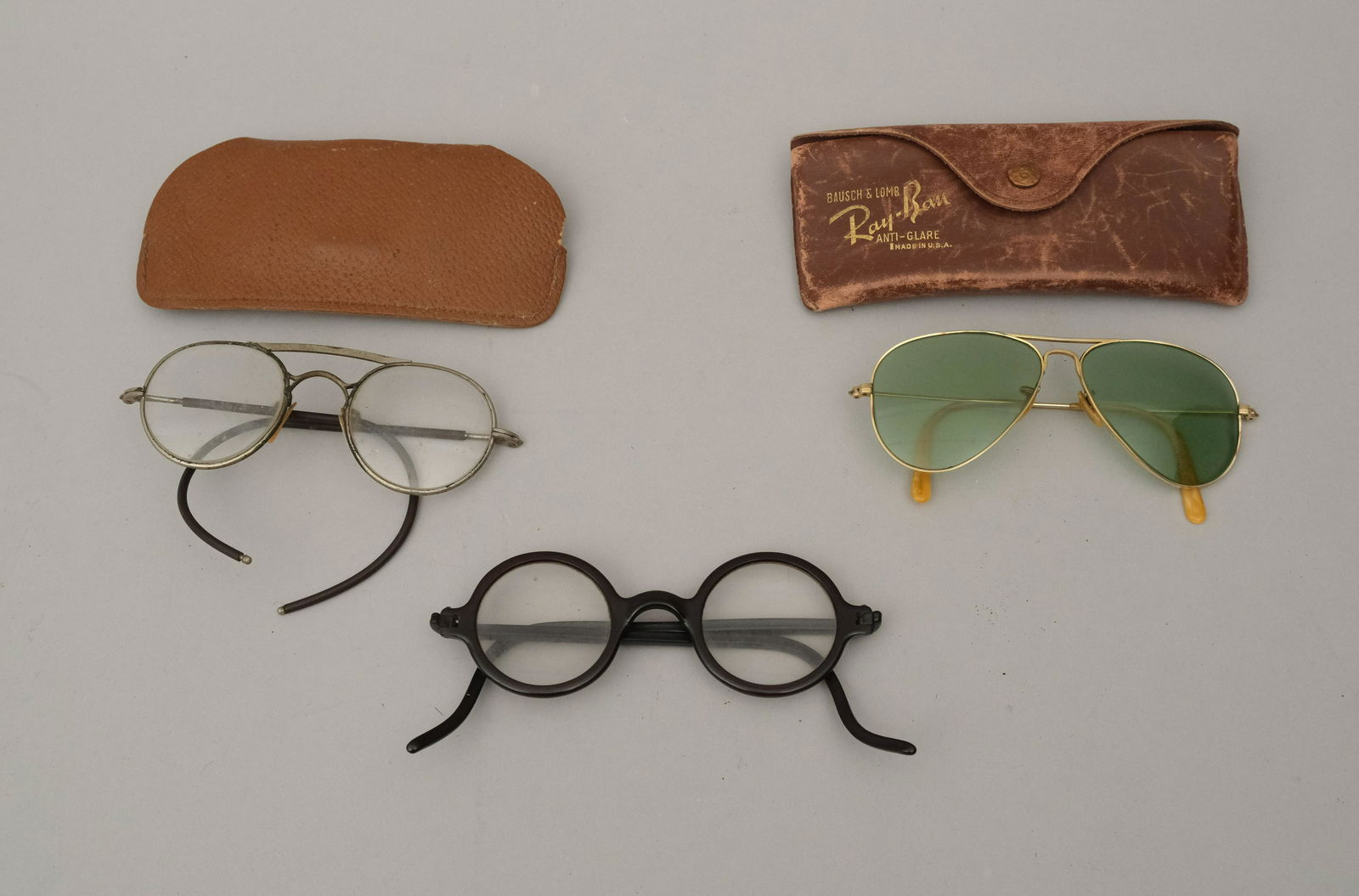 Lot of Vintage Eyeglasses & Sunglasses: Comprising a pair of Ray-ban with Bausch & Lomb lenses, a pair of round frame spectacles, and a pair of Wilsonite glasses, also with Bausch & Lomb lenses.