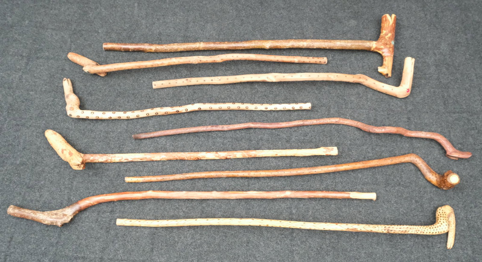 Nine Walden Macpherson Folk Art Carved Canes: Group of nine root art walking sticks, variously decorated with carved and applied elements. Macpherson was an avid woodworker and naturalist who constructed his art using exclusively found and scaven