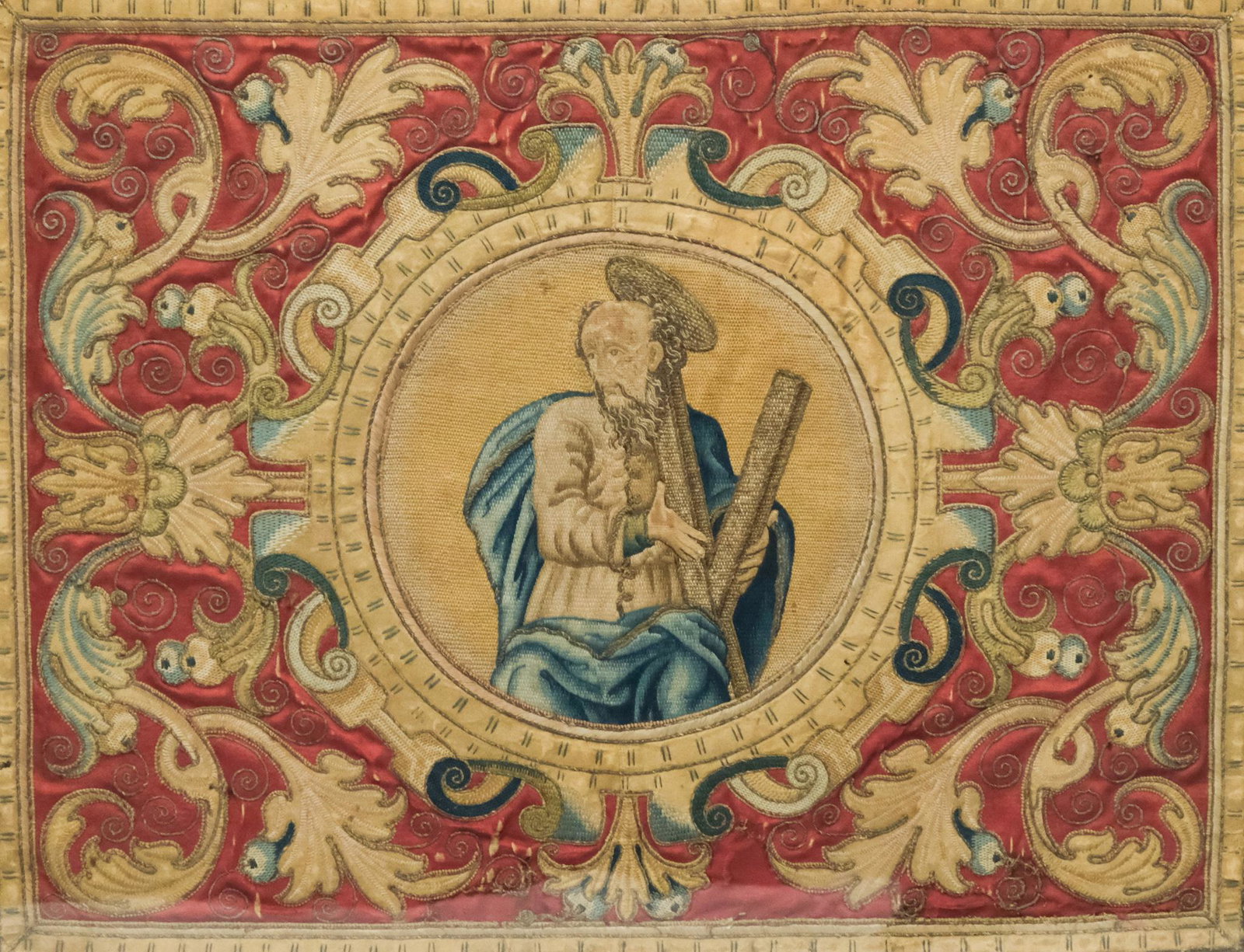 18th C. Antependium Embroidery of St. Andrew: (Possibly 17th Century or earlier. Identified on verso label from John Wananmaker as 16th Century). Depicting St. Andrew in a needlepoint and embroidered roundel, surrounded by scrolling foliates acce