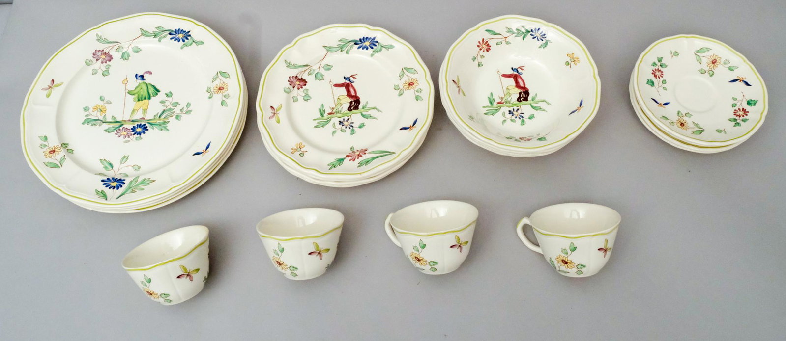 Group of Longchamp Moustiers Porcelain: Decorated in the French Provincial style. Comprising (4) 7 1/4" soup bowls, (4) 8 1/2" salad plates, (4) 10 1/2" dinner plates, and (4) teacups with saucers.