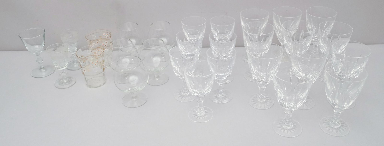 Large Lot of Crystal Stemware: Consisting of eleven Kosta-Boda water goblets, seven wine glasses, as well as nine other glasses from various makers. Kosta-Boda glasses all marked as such on bottom. Largest glass 6", smallest 4 1/2"