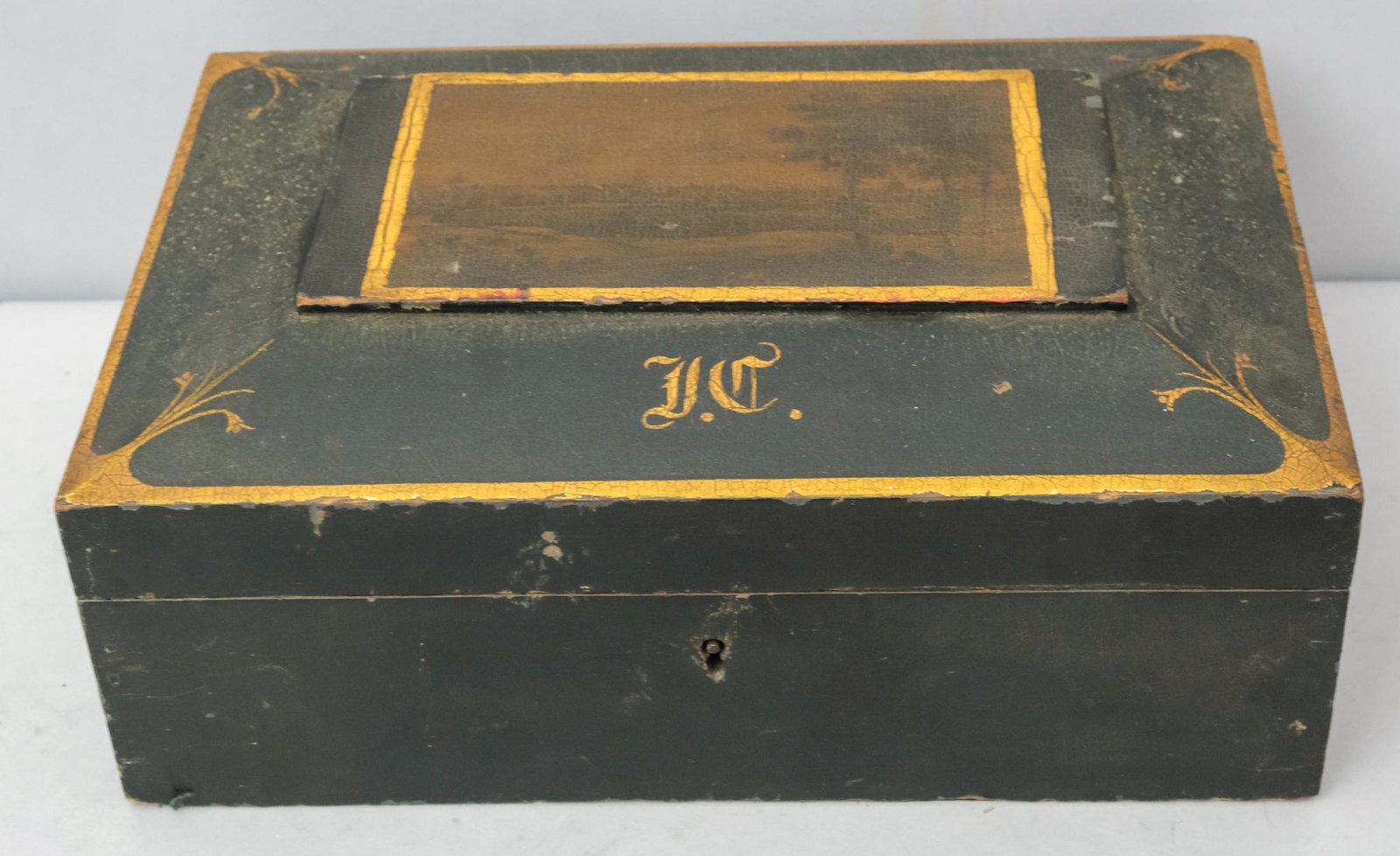 Antique Black & Gold Painted Jewelry Box: With Sepia landscape painted at center over a period monogram. Interior lined in tooled gold paper with mirror. Measures 8" X 12" X 5".
