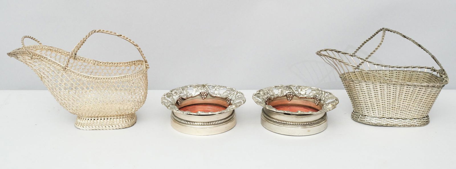 2 Silverplate Woven Bottle Caddies & Coasters: 2 Woven silverplate wine bottle caddies or holders, in the style of Christofle, one marked "France". Together with a pair of wine bottle coasters with pierced vine borders and engraved armorials. coas