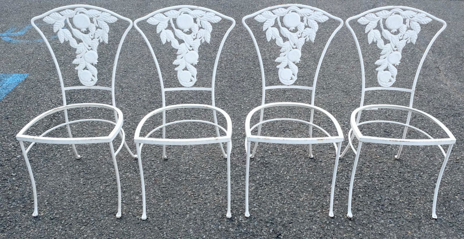 Metal Patio Chairs Painted White: Mid-20th century metal patio chairs painted white, backs decorated with pomegranate relief, 33 1/2" H x 19" W x 18" L.