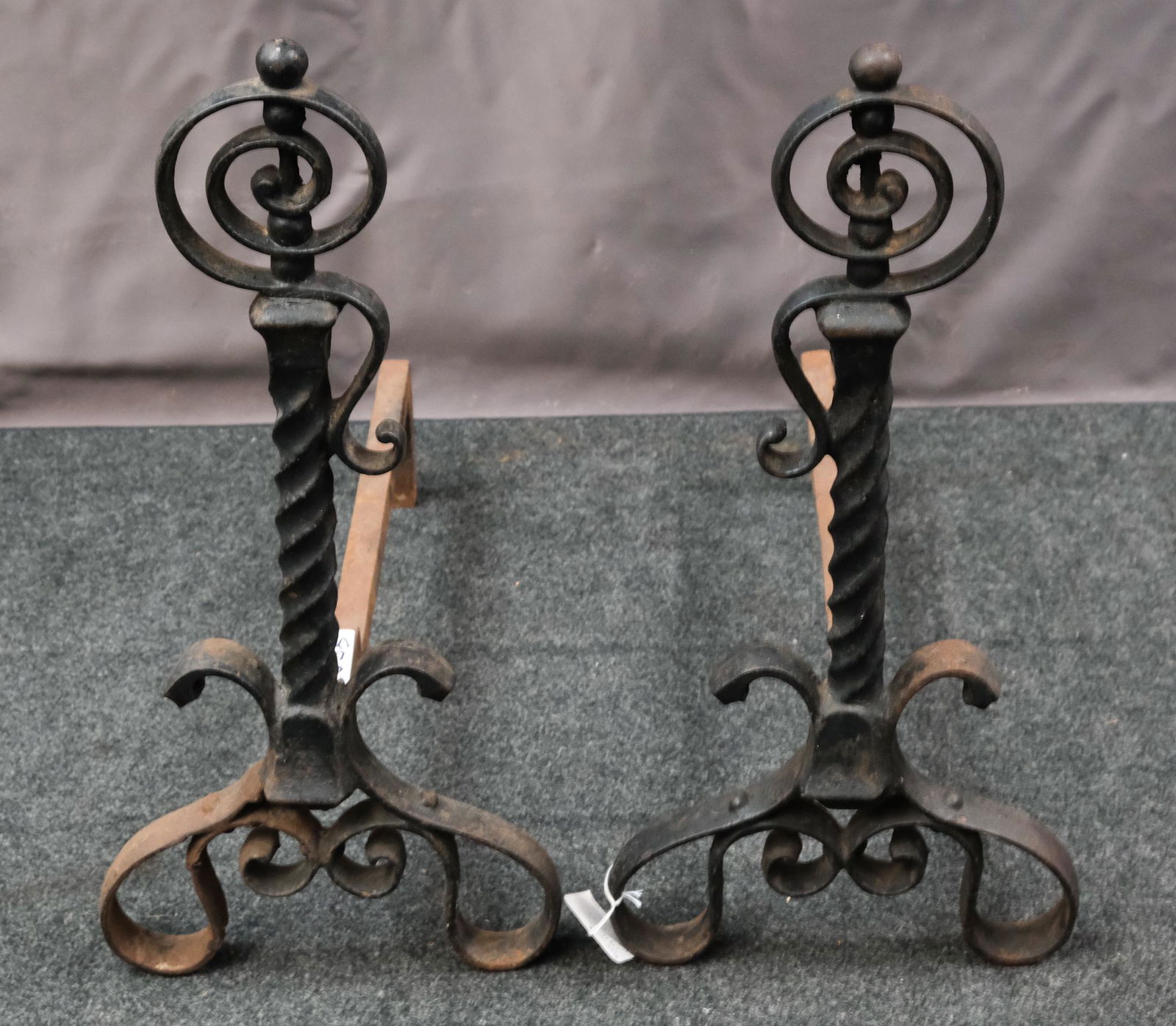 Pair of Wrought Iron Andirons: Pair of 19th century arts and crafts wrought iron andirons with twisted stems and scrolled accents, 20" H x 9 1/2" W x 18 1/2" L.