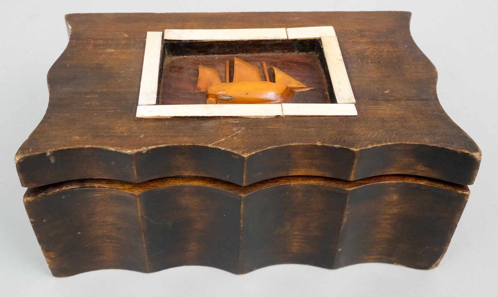 Antique Folk Art Sailor's Keepsake Box: Scalloped form wooden box with inset panel of clipper ship framed in bone. 5" H x 7 1/2" D x 12" W.