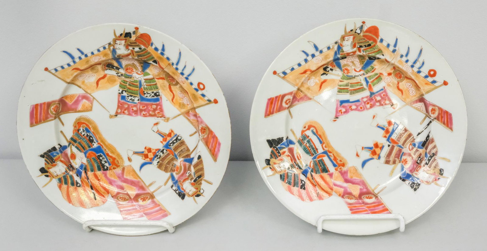 2 Antique Meiji Period Porcelain Japanese Plates: Decorated with samurai and gilt borders. Marked with iron red characters on verso. 8 1/4".