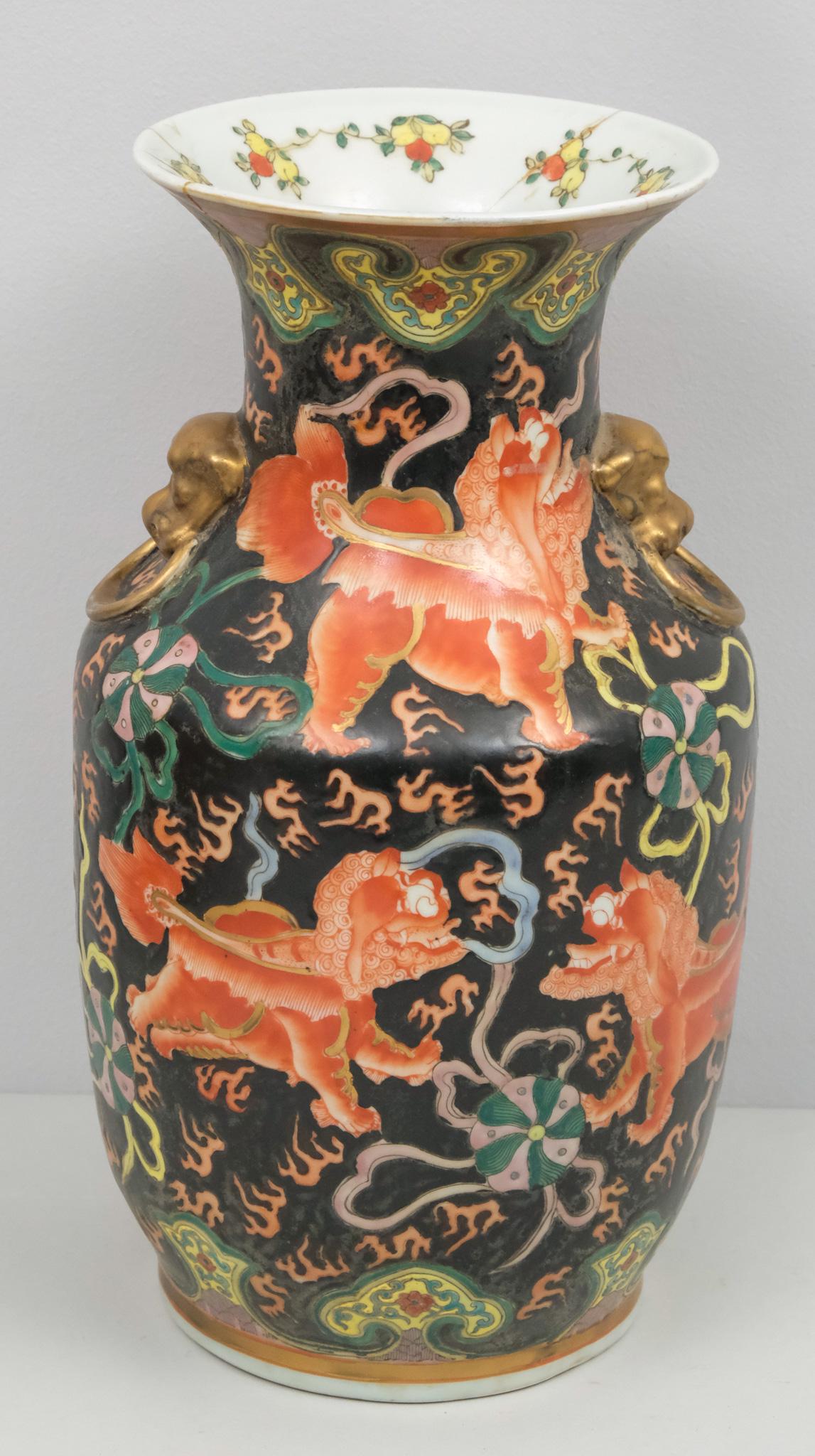 Chinese Black Field Foo Dog Vase: With golden face handles and over enamel decoration of foo dogs and ribbon balls. Red character mark. 14 1/2".