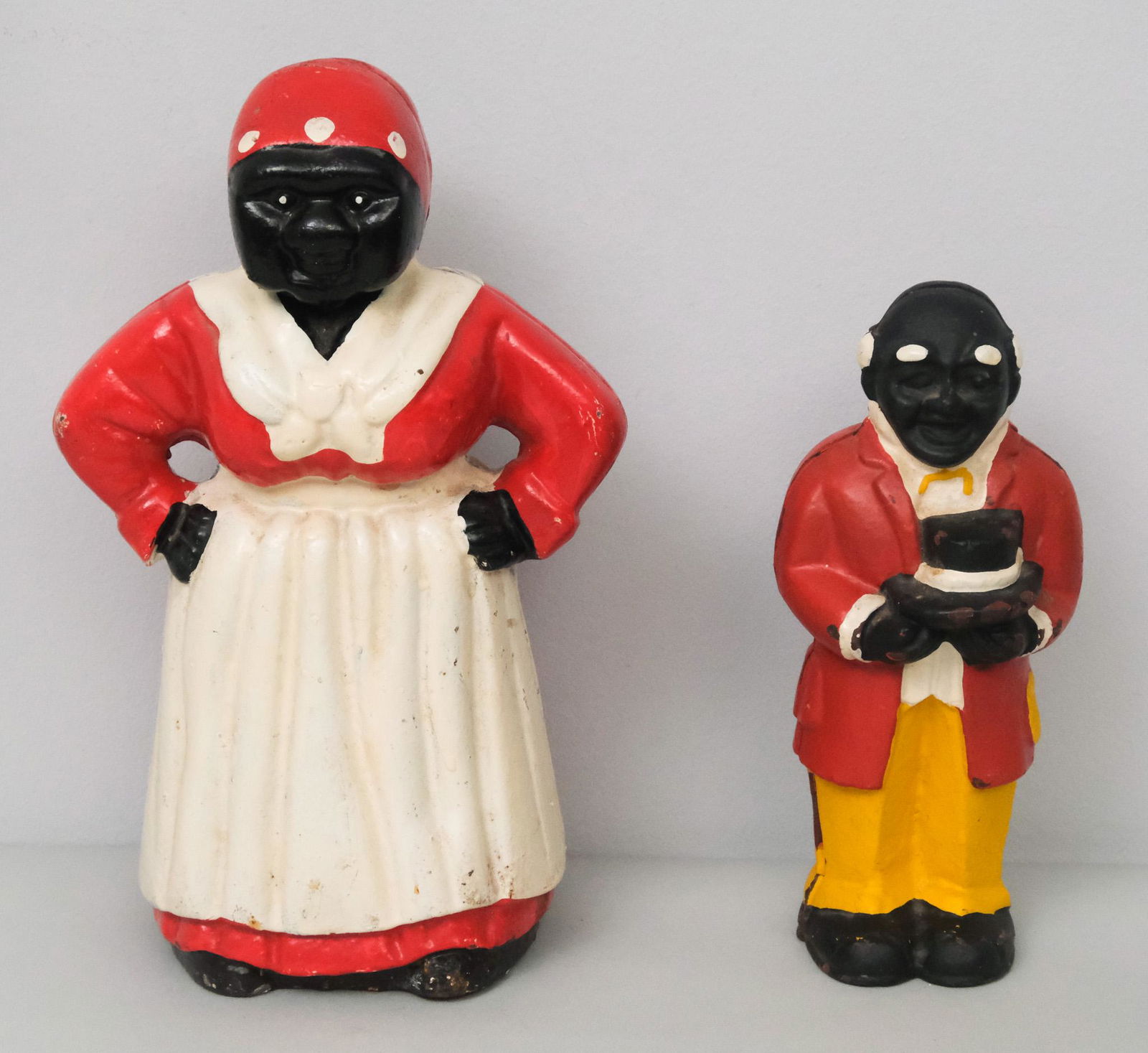 Set of Cast Iron Banks: Set including vintage cast iron Uncle Moses coin bank (8" H x 3 1/2" W x 3" L) and a vintage cast iron Aunt Jemima coin bank (10 1/2" H x 6" W x 4 1/2" L).