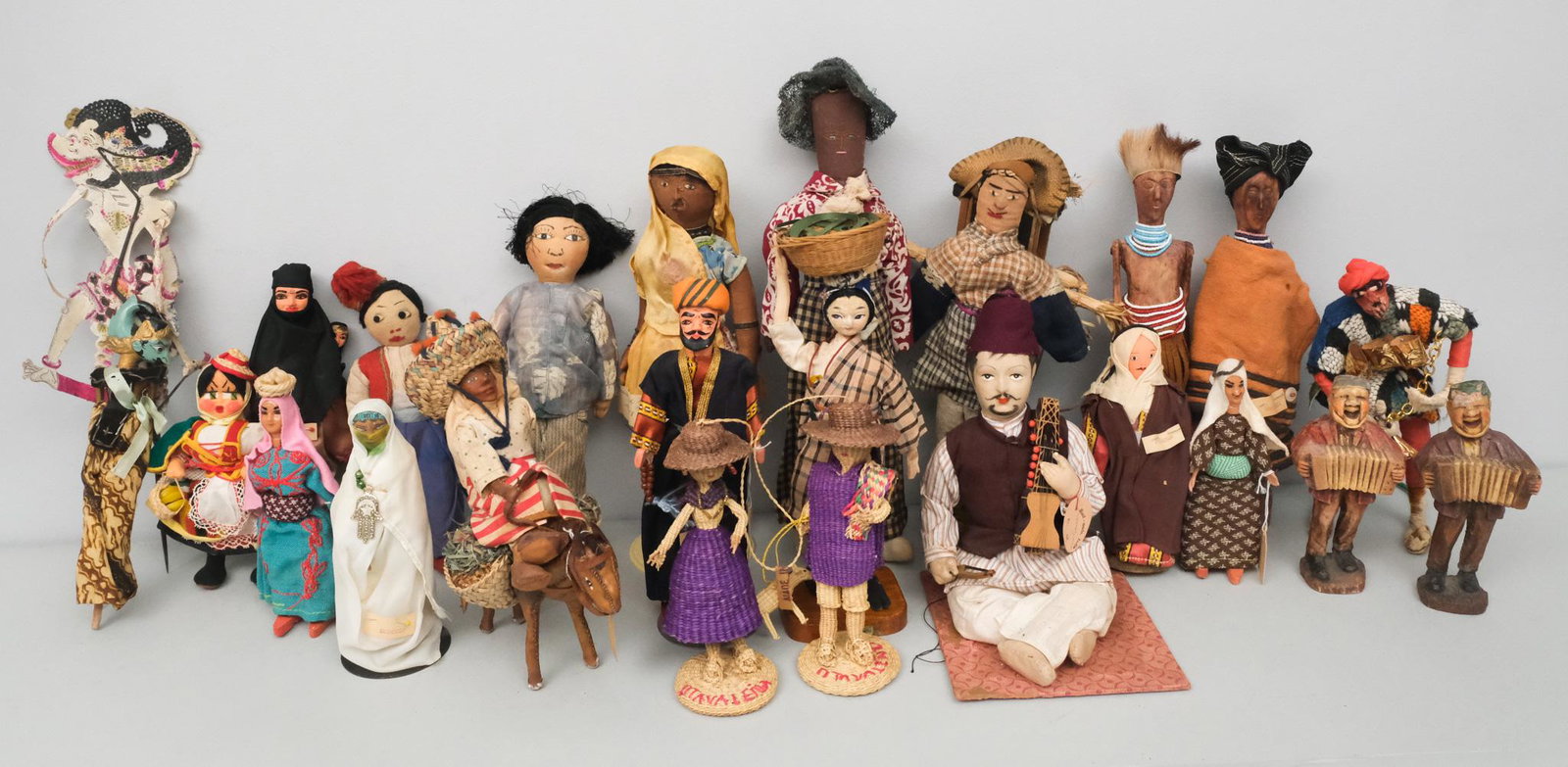 Group of Vintage International Souvenir Dolls: Large group which includes a carved wooden couple from Rhodesia (12"), Puerto Rican man (15"); a woven couple from Ecuador (7"); a seated musician from India (9"); a woman from Trinidad (12"); a Moroc