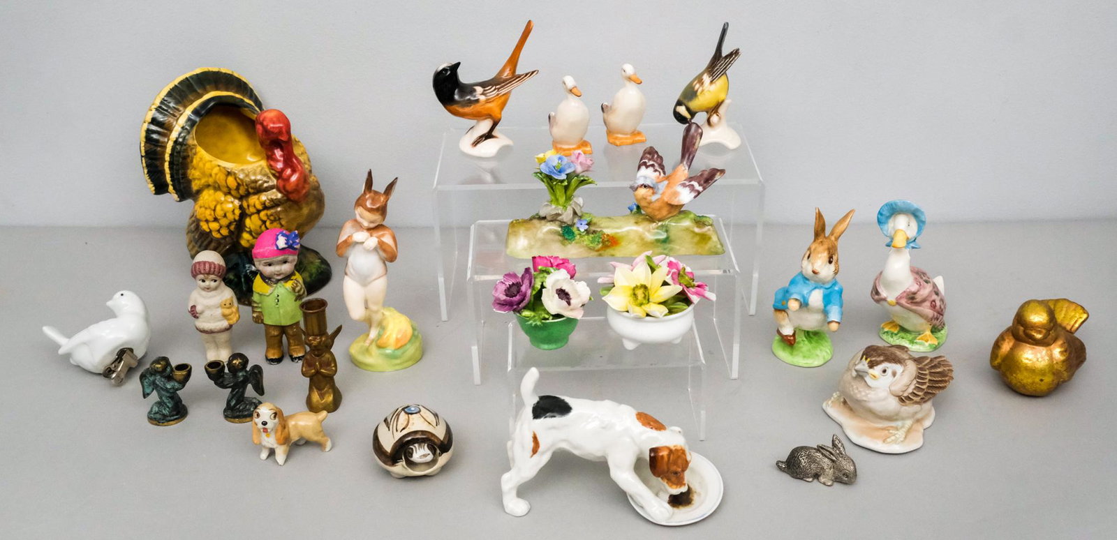 Lot of Porcelain Figurines Including Royal Doulton: Comprising 2 ducks, a dog, and "Baby Bunting" by Royal Doulton, a Peter Rabbit and Jemima Puddleduck (base flake), an Augarten sparrow, 2 bouquets and a bird next to flowers by Crown Staffordshire (al