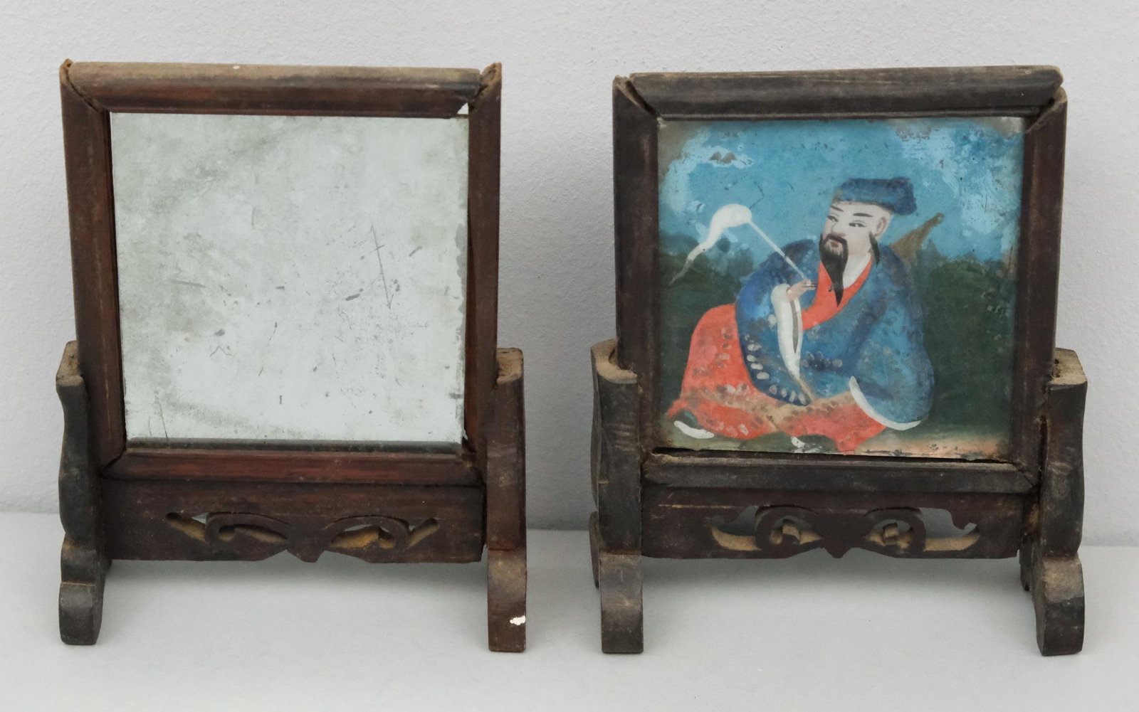 Pair of Chinese Verre Eglomise Portraits on Stands: Antique pair. One lacking portrait, but retaining back mirror. Both still in wooden stands. 4 1/4" x 5 1/4".