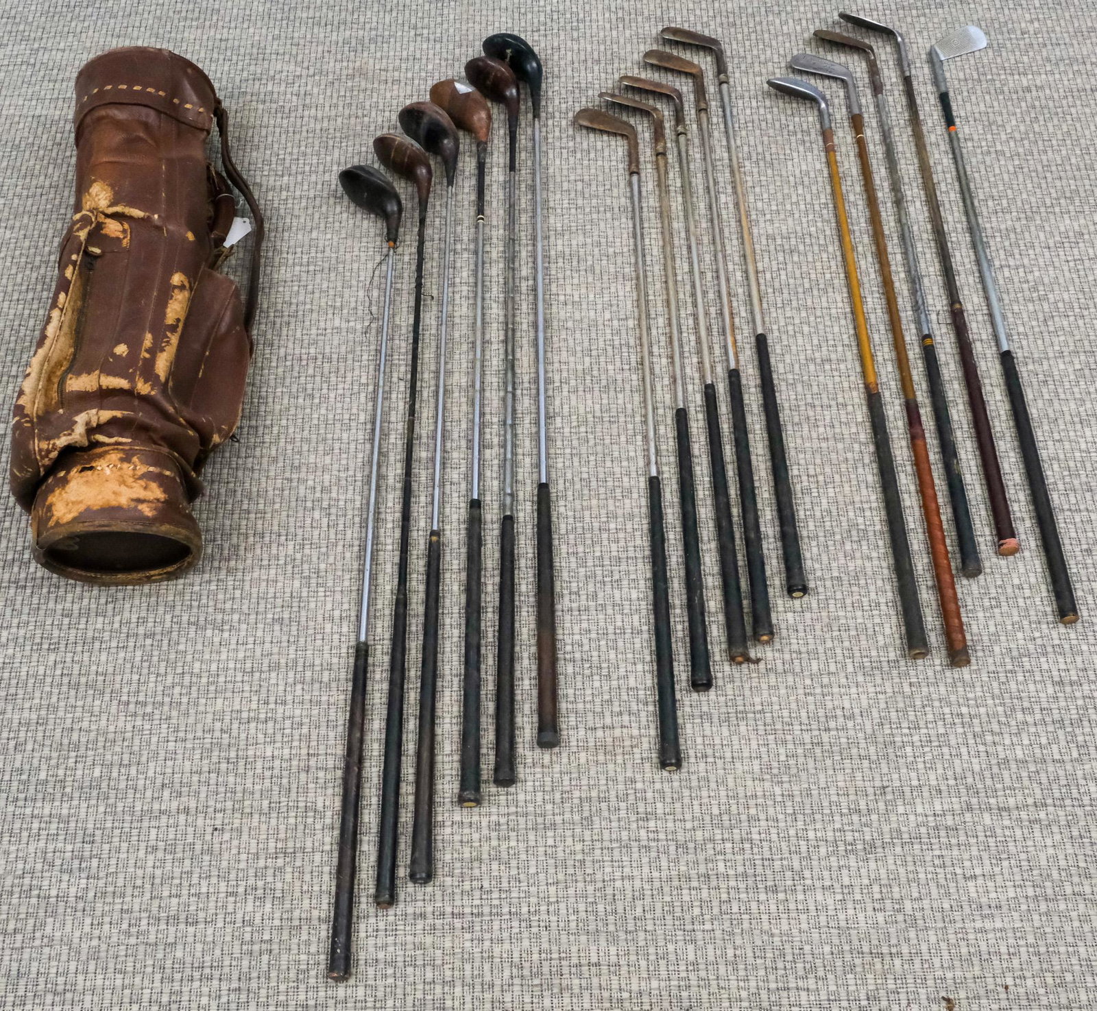 Set of Vintage Golf Clubs: Comprising a Henry Cotton putter, two Spalding four-woods, three other woods, an Abercrombie & Fitch eight iron, and a selection of other iron (including Kroydon), all in leather bag.