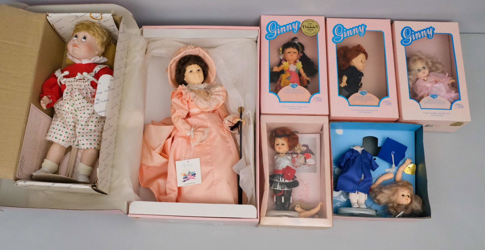 5 Ginny Dolls, 1 Effanbee and 1 Design Debut doll: Lot consisting of 5 Vogue Dolls "Ginny" dolls including "Island Ginny", "Policewoman", "Sweet 16", "Flapper" and "Graduation Day", together with an Effanbee "Little Old New York Collection- Uptown Sut