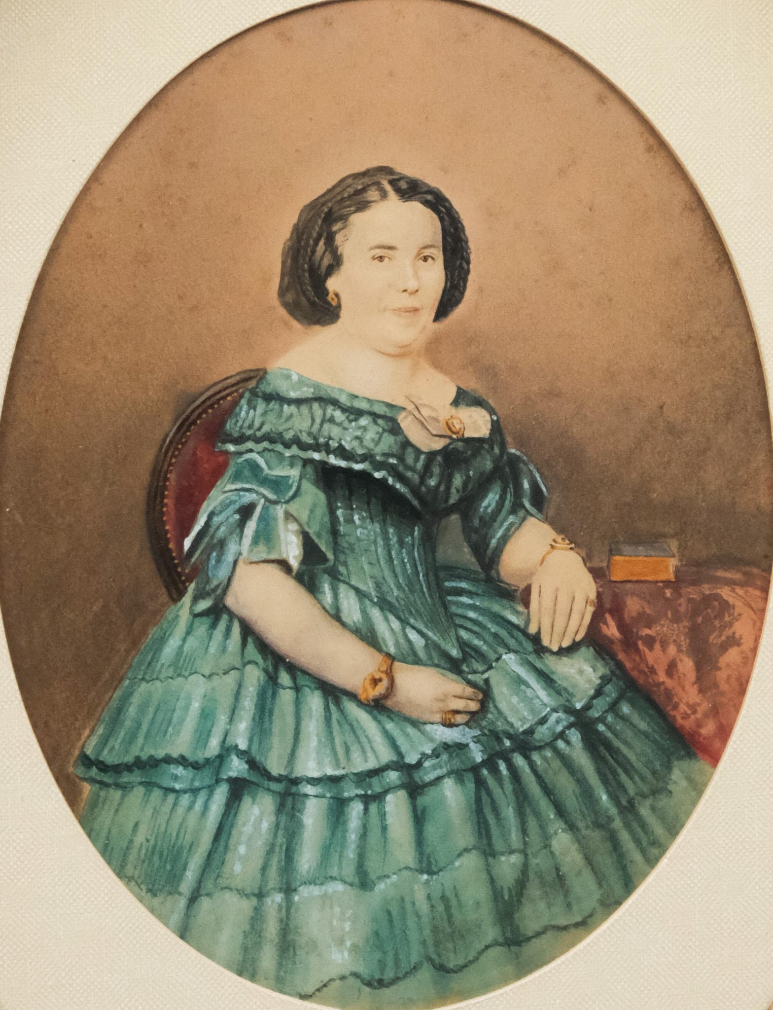 American School, Portrait of a Woman: American, 19th century watercolor and gouache on paper depicting a dark-haired woman in a blue gown, seated in a red chair, 6 3/4" x 5 1/4" sight size, 14" x 12" framed.