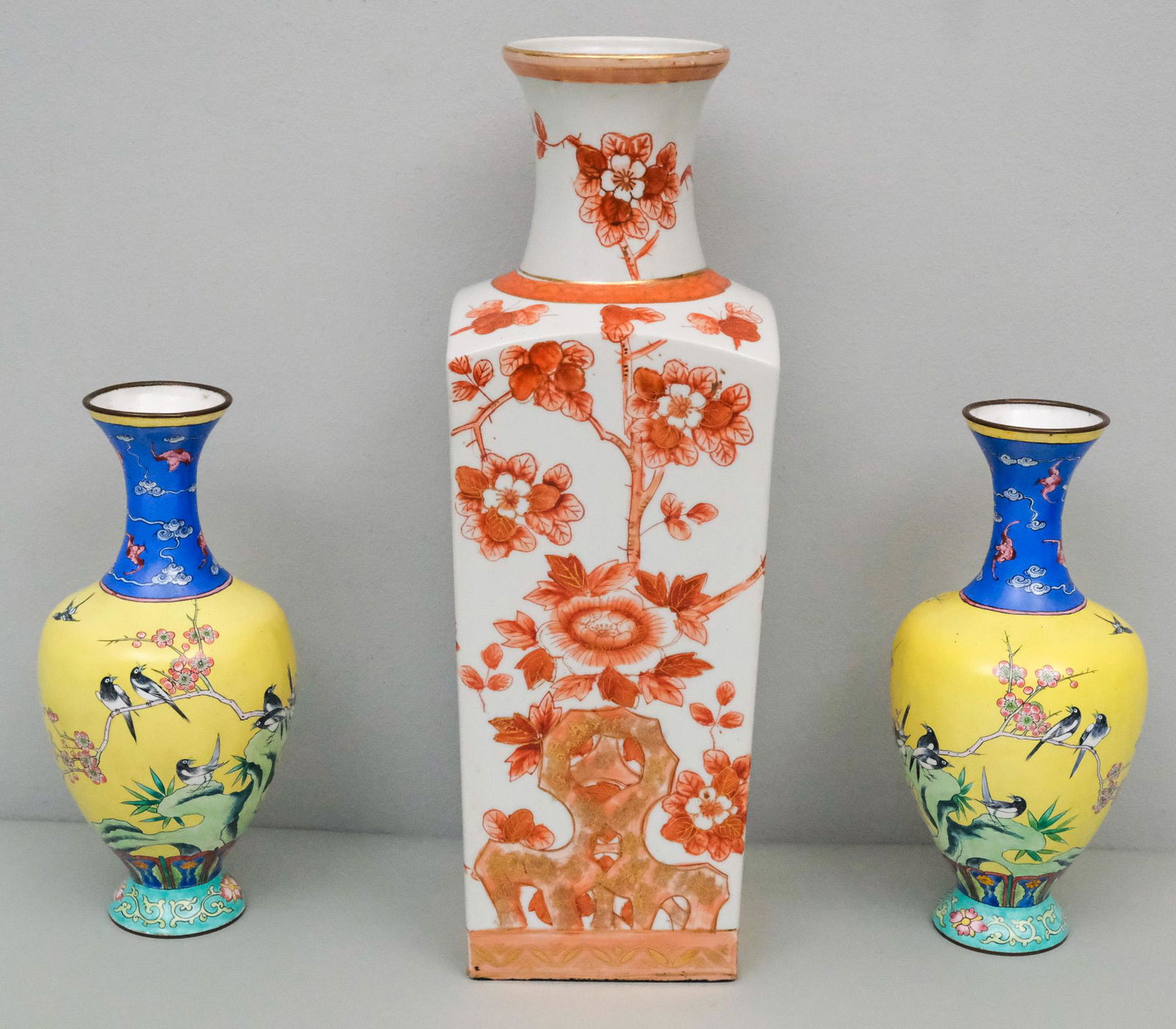 Lot of Chinese Antiques: Comprising a pair of enamel on brass vases with bird decoration (damage and restorations), and a square bodied vase with rust flowers (drill hole). 9" and 14 1/2".