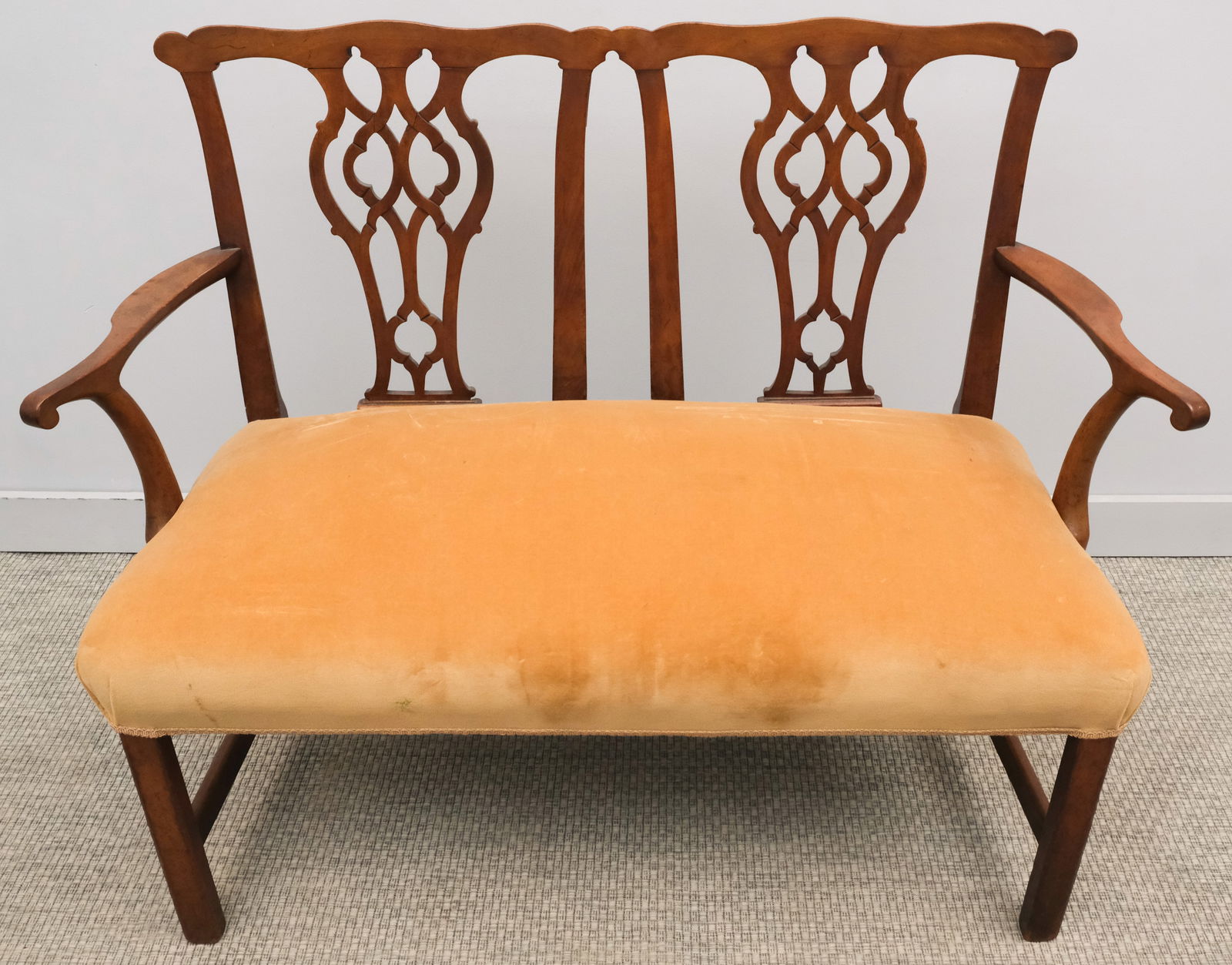 Chippendale Mahogany Settee: Early 19th century Chippendale mahogany settee with tan velvet upholstery, pierced splats, shaped arms and square legs, 47" X 24" X 37".