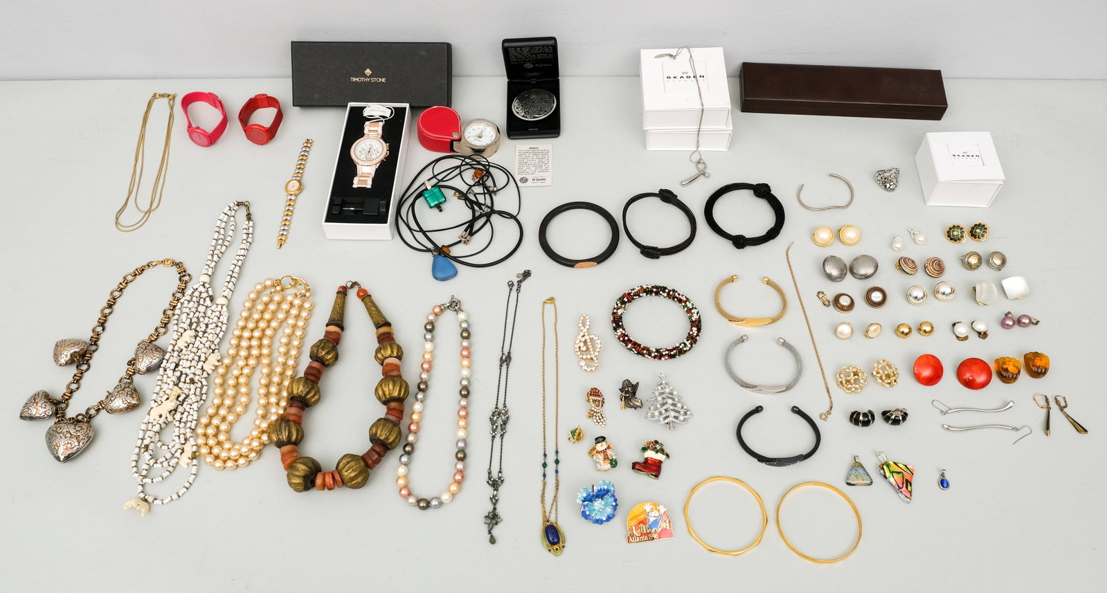 Group Very Nice Costume Jewelry: This group of costume jewelry includes pins, necklaces, bangle bracelets, earrings and more. Items are of various age and made of various materials. Featuring signed Skagen, a group of Christmas relat