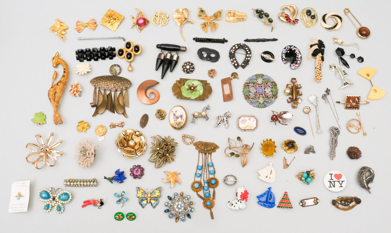 Large Group of Costume Jewelry Brooches and Pins: This large group of costume jewelry contains quality pieces of various design, material and age. Consisting mostly of pins and brooches. Featuring signed pieces by Napier, Trifari, Coro, Avon, and mor