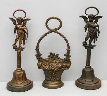 Group of 3 Antique Cast Doorstops: Comprising 2 English cupid form examples and a basket of flowers. Tallest 17 3/4".