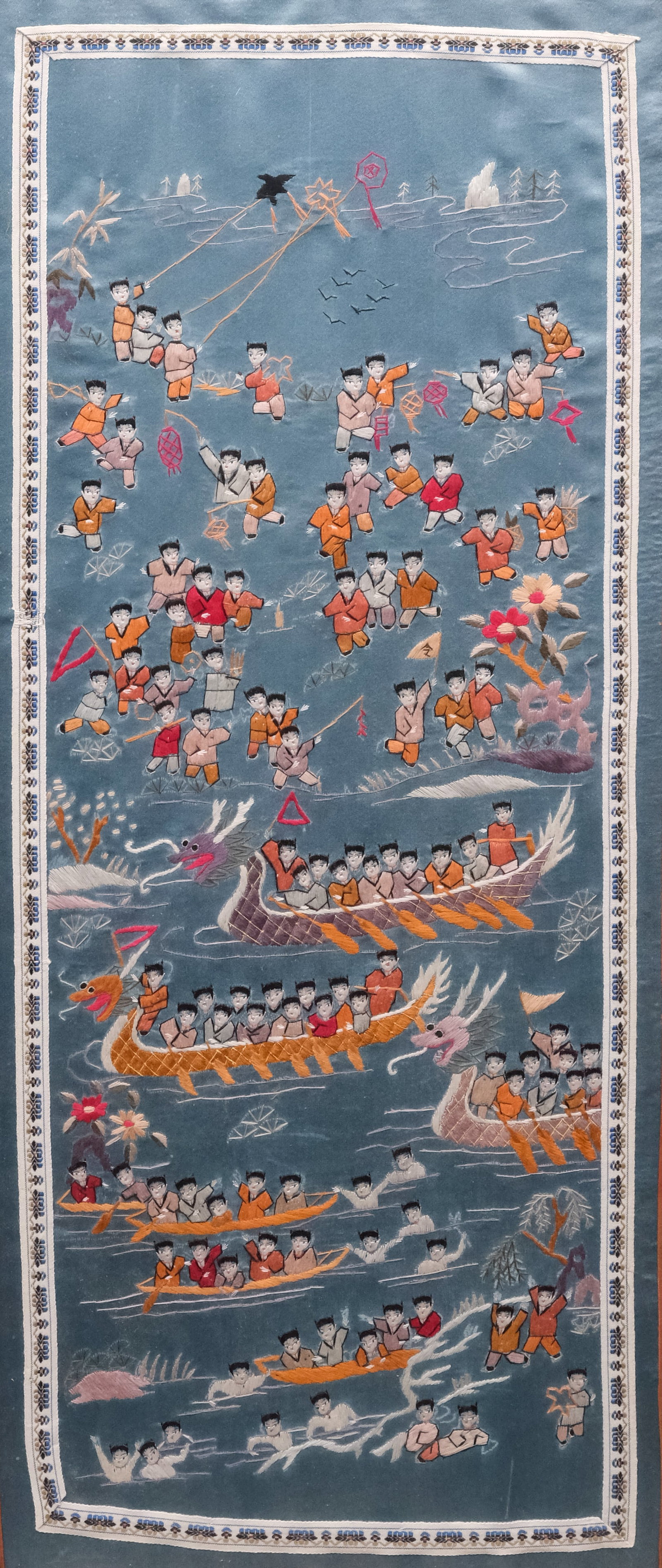 Chinese School, Embroidered Silk Panel: Chinese, early 20th century embroidered silk panel depicting dozens of small children playing in and around the water, 24 1/2" x 11 1/2" sight size, 27" x 14" framed.
