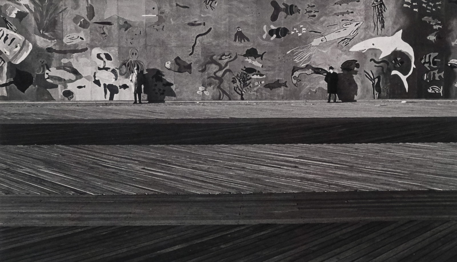 N. Jay Jaffee, Coney Island: N. Jay Jaffee (American, 1921-1999), photograph on paper depicting two men standing against a wall painted with sharks and other sea creatures, 7 1/4" x 12 1/4" sight size, 17 1/4" x 21 1/4" framed.