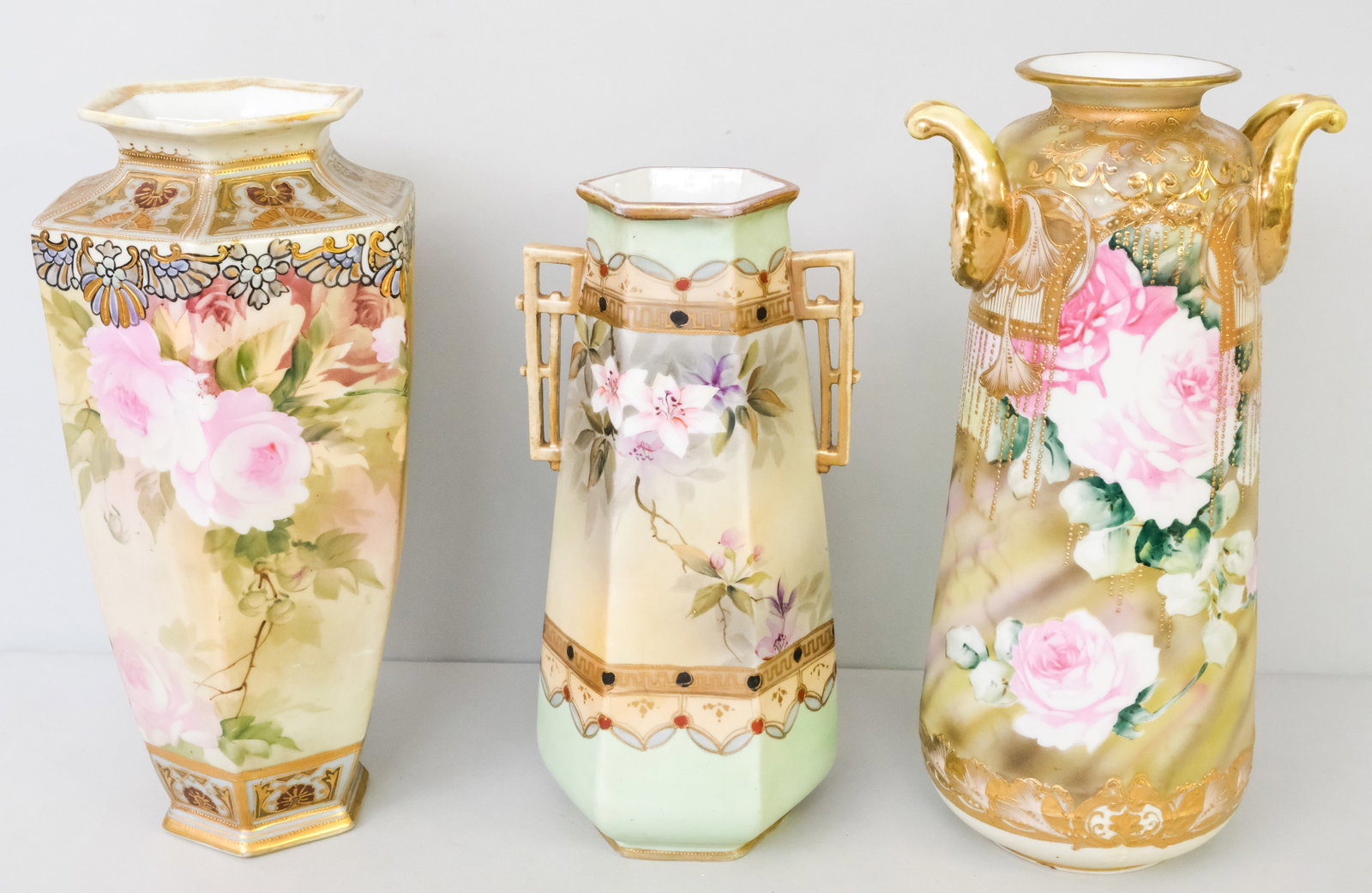 Three Antique Nippon Porcelain Vases: Comprising a Morimura Gumi vase with weeping Moriage, a Morimura hexagonal vase, and an E.E. Nippon hexagonal vase with geometric handles. 12" to 14".