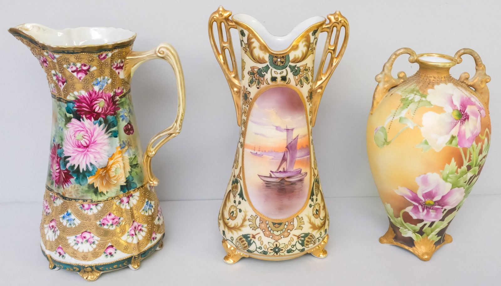 Two Antique Nippon Porcelain Vases & A Pitcher: Comprising a Morimura Gumi pitcher with heavy Moriage gilding, a Morimura Gumi vase with matte decor, and a Morimura footed vase. 11 1/4" to 13 1/2".