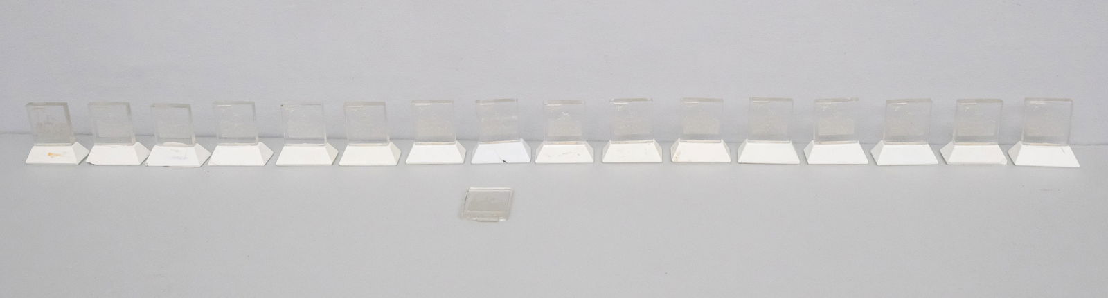 Intaglio Glass Place Card Holders: Group of 16 intaglio glass place card holders decorated with a horseback hunter and his dogs, with stone base, one glass panel is separate from base, 2 1/2" H x 2" W x 1" L.