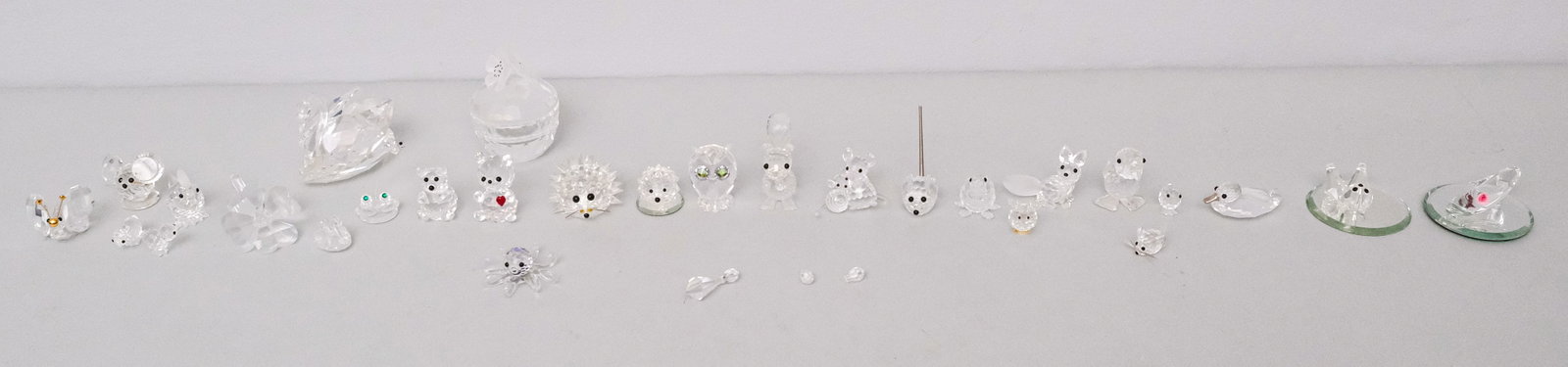 Collection of Swarovski Crystal Figurines: Group of over 20 Swarovski figures, together with two Glass Baron figurines on mirrored plateaus (one with detached pieces). Flower box 2 1/2".